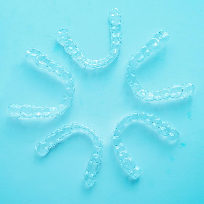 5 invisalign clear aligners on a blue background