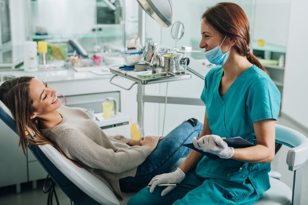 woman in dentist chair smiling at female dentist