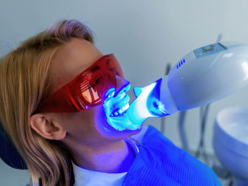 woman at dentist getting professional teeth whitening